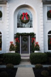 Home exterior Christmas Decor with wreaths, garland and lights.